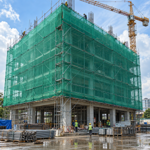 Lưới công trình màu xanh bao che giàn giáo quanh tòa nhà đang thi công